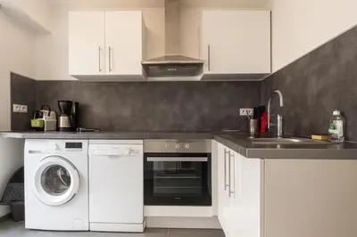 a kitchen with a washing machine and a sink at Appartement confortable avec balcon - Proche Gare Riquier SNCF in Nice