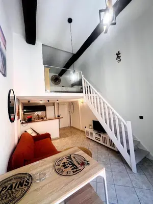 a living room with a staircase and a couch at Duplex Place Massena in Nice