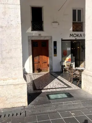 a store front with a wooden door and a table at Duplex Place Massena in Nice