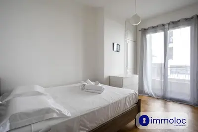a white bedroom with a bed and a window at Apartment neighborhood Liberation in Nice
