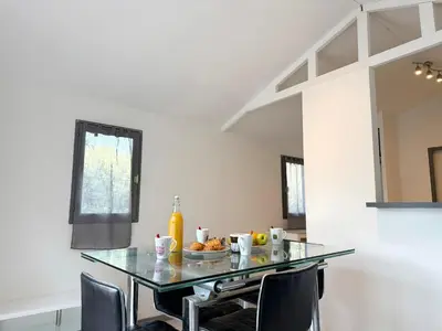 a dining room with a glass table and chairs at Charmant chalet avec jardin in Nice