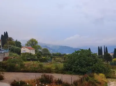 a house on a hill with trees and a river at F2 vue mer et montagne au calme in Nice