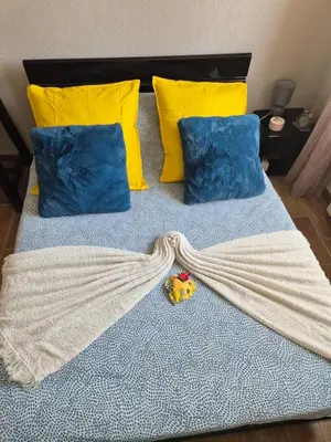 a bed with yellow pillows and a blanket on it at F2 vue mer et montagne au calme in Nice
