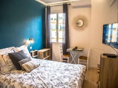 a bedroom with a bed and a tv and a window at Studio port de Nice in Nice