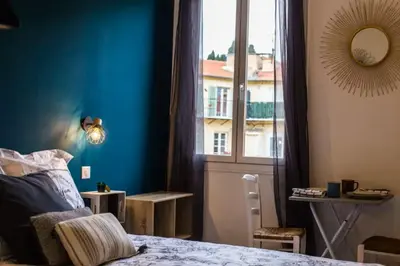a bedroom with a bed and a large window at Studio port de Nice in Nice