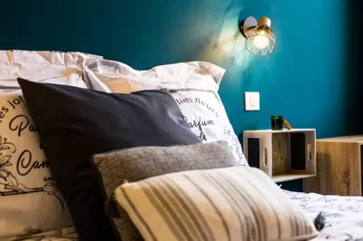 a bed with black and white pillows and a blue wall at Studio port de Nice in Nice