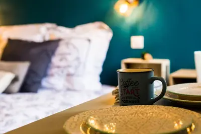 a coffee cup sitting on a table next to a bed at Studio port de Nice in Nice