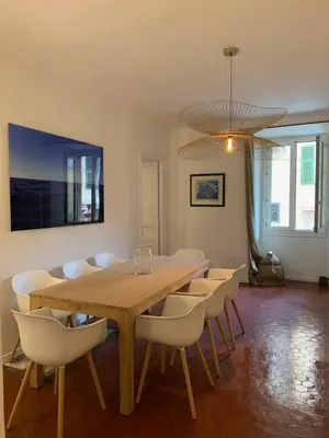 a dining room with a wooden table and chairs at Exceptional Location Beaches Cours SALEYA in Nice
