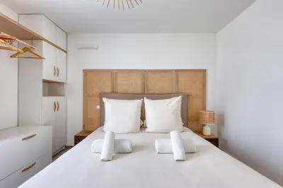 a bedroom with a large white bed with white pillows at Les Vagues du 5e 4 personnes , 2 chambres , clim , wifi , Cap3000 à pied , parking in Saint-Laurent-du-Var