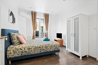 a bedroom with a blue couch and a tv in it at Nice Renting - PAGANINI - New Lovely Cosy Flat in Heart of Nice in Nice