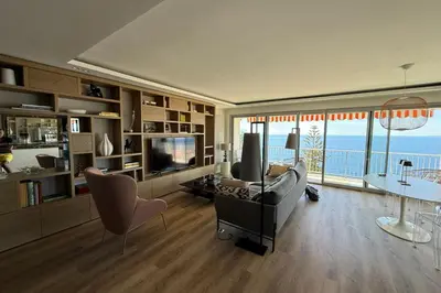 a living room with a couch and a television at Superb apartment with exceptional sea view in Nice