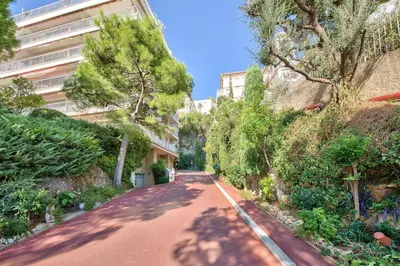 an empty street with trees and a building at Superb apartment with exceptional sea view in Nice