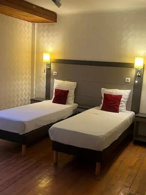 two beds with red pillows in a hotel room at T2 Pasteur in Nice
