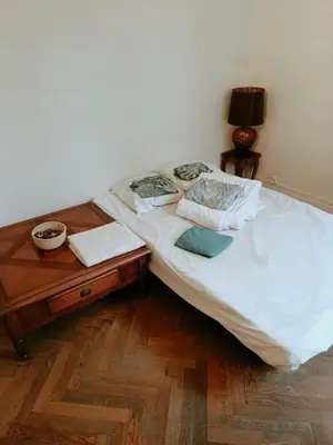 a bed in a room with a nightstand and a bed sidx sidx at Chambre niçoise in Nice