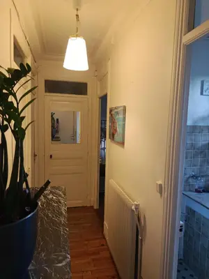 a hallway with a white door and a potted plant at Chambre niçoise in Nice