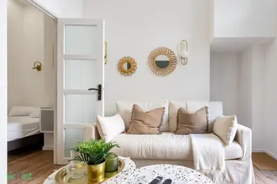 a living room with a white couch and a table at WeHost D4 - La Chic Cour 2 people Near sea in Nice