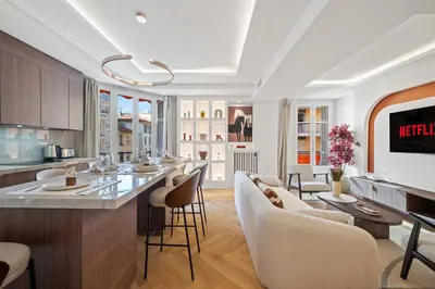 a kitchen and living room with a bar and chairs at luxueux, spacieux dans le quartier du port in Nice