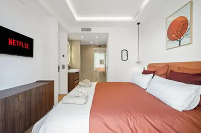 a bedroom with a large bed with orange and white pillows at luxueux, spacieux dans le quartier du port in Nice
