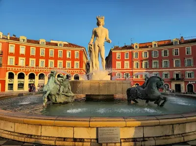 a fountain with two statues in front of a building at Central & Beach in Nice