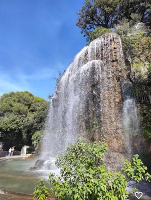 a waterfall on the side of a hill with trees at Central & Beach in Nice