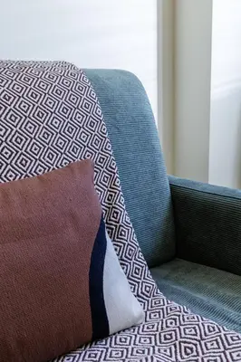 a pillow sitting on a couch next to a chair at 44 LAMARTINE - Charmant 2 pieces - Centre-ville in Nice