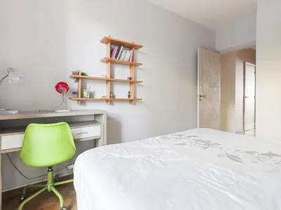 a bedroom with a green chair next to a desk at Apartment Le Sirius by Interhome in Nice
