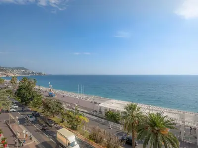 a view of a beach and the ocean with palm trees at Holiday Home Les Genêts by Interhome in Nice