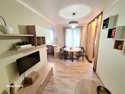 a living room with a large television and a table at Cosy one bedroom apartment to Nice in Nice