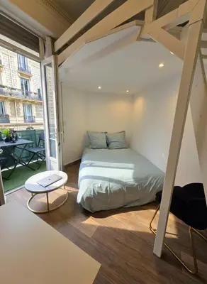a bed in a room with a large window at Cozy studio, balcony & AC, Heart of Nice in Nice