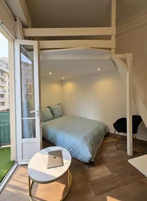 a bedroom with a bed with a laptop on it at Cozy studio, balcony & AC, Heart of Nice in Nice