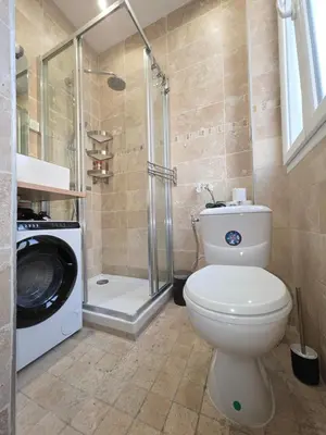 a bathroom with a toilet and a washing machine at Cozy studio, balcony & AC, Heart of Nice in Nice
