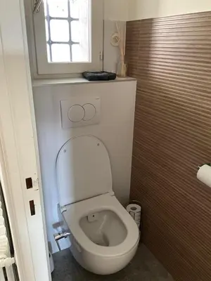 a white toilet in a bathroom with a window at Maison avec vue mer et jacuzzi à 15 mn du centre in Nice