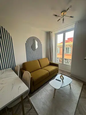 a living room with a couch and a table at MASSENA 42 in Nice
