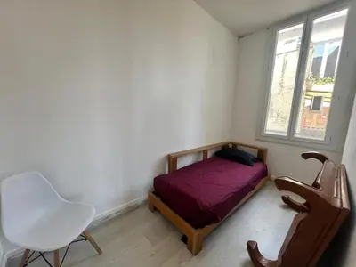 a bedroom with a bed and a chair and a window at Charmant et cosy 3pcs in Nice
