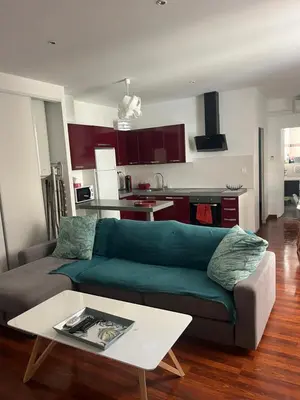 a living room with a green couch and a table at cosy appartement in Nice