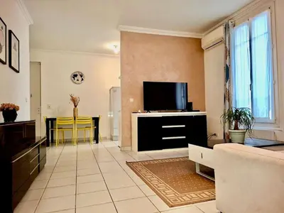 a living room with a couch and a tv at 2 Pièces en étage au Centre-ville de Nice in Nice