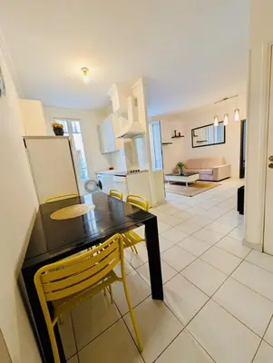 a kitchen and dining room with a table and chairs at 2 Pièces en étage au Centre-ville de Nice in Nice