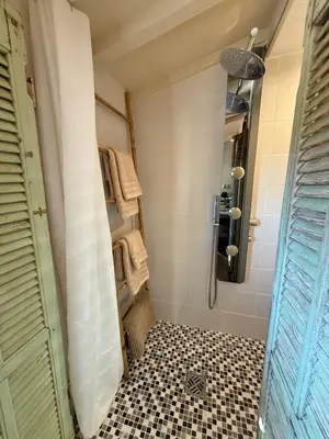 a bathroom with a shower and a black and white tile floor at Studio Place Rossetti - Old Nice Center in Nice