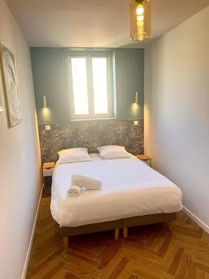 a bedroom with a large bed with a window at MASSENA 27 in Nice