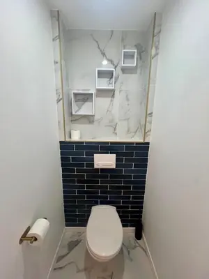 a bathroom with a white toilet and blue tiles at MASSENA 27 in Nice