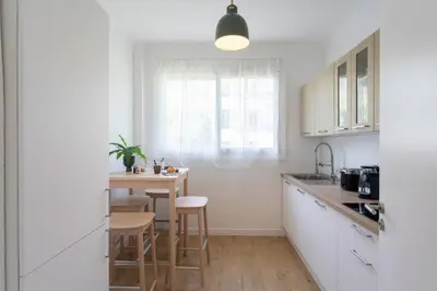 a kitchen with white cabinets and a table and chairs at L9 Marechal 2BDR Marechal, 5 min Sea10 min Old Town Parking AC in Nice