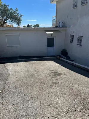 a parking lot in front of a white building at Appartement dans villa vue mer piscine partagée in Saint-Laurent-du-Var