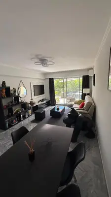 a living room with a couch and a table at Modern apartment with sunny terrace in Nice