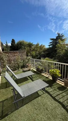 a picnic table and a bench on the grass at Modern apartment with sunny terrace in Nice