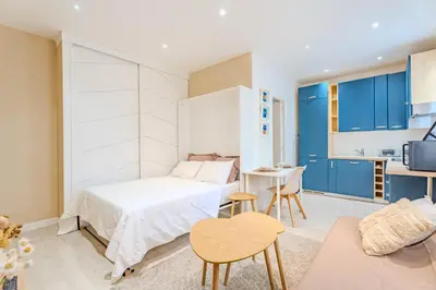 a small bedroom with a bed and a table at Fontaine de la Ville in Nice
