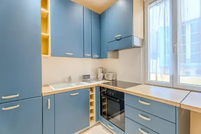 a kitchen with blue cabinets and a window at Fontaine de la Ville in Nice