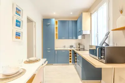 a kitchen with blue cabinets and a counter at Fontaine de la Ville in Nice