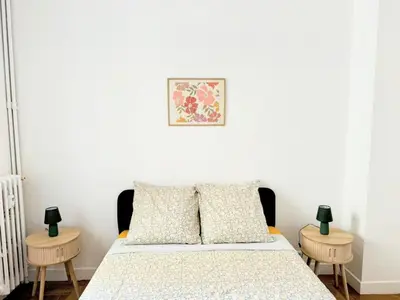 a bedroom with a bed with two tables at Charmant appartement avec balcon, près de la plage et Promenade des Anglais in Nice