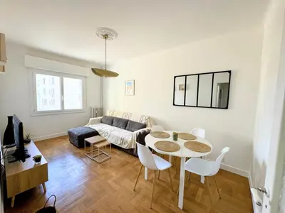 a living room with a table and a couch at Charmant appartement avec balcon, près de la plage et Promenade des Anglais in Nice