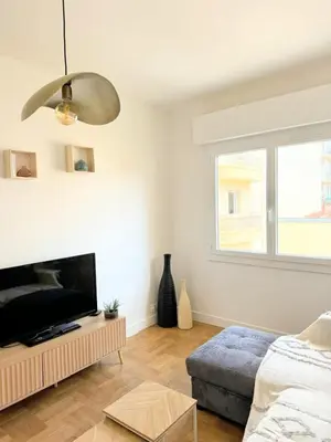 a living room with a flat screen tv and a couch at Charmant appartement avec balcon, près de la plage et Promenade des Anglais in Nice